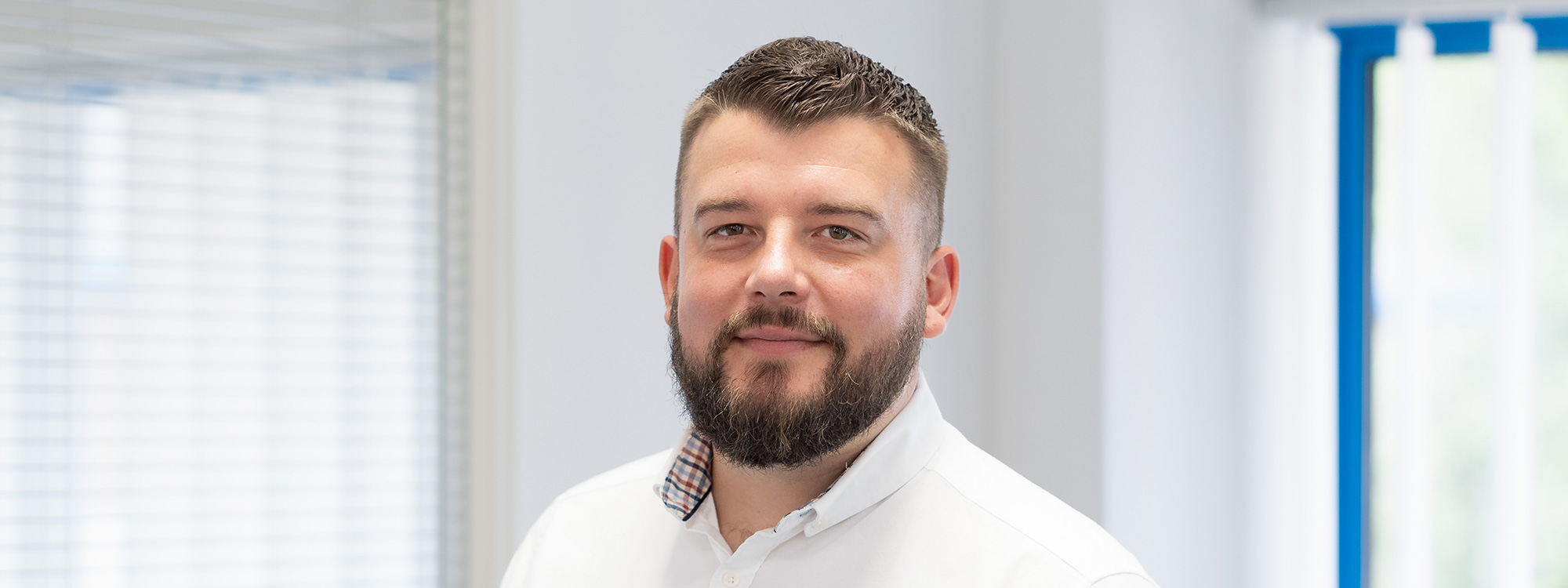 man smiling at camera in white shirt